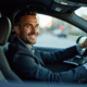 Homme conducteur souriant dans une voiture moderne