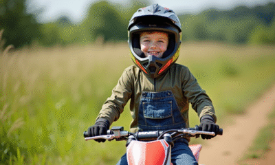 Jeune garçon souriant avec casque sur un dirt bike en plein air