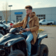 Jeune homme en windbreaker avec quad neuf en concession