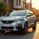Peugeot 3008 argentée sur une rue ensoleillée de banlieue